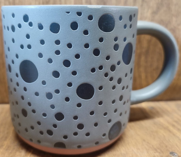 Tasse grau mit dunklen Punkten